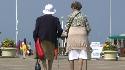 Deux personnes &acirc;g&eacute;es marchent le long de la plage &agrave; Deauville (Calvados), le 30 ao&ucirc;t 2000. (MYCHELE DANIAU / AFP)