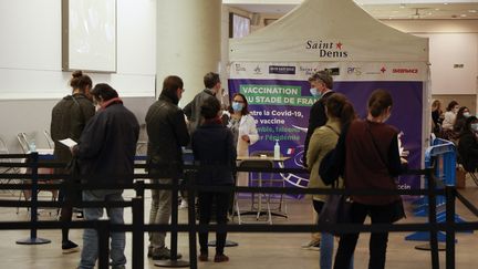 Des personnes attendent de recevoir une dose de vaccin contre le Covid-19 au Stade de France à Saint-Denis, dans le nord de Paris, le 23 avril 2021. (LUDOVIC MARIN / AFP)