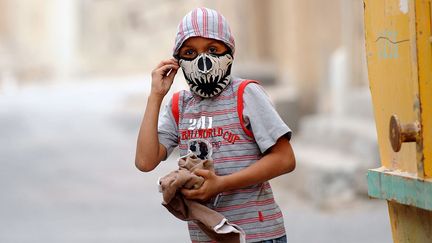 Un jeune manifestant ajuste son masque lors d'affrontements avec la police &agrave; Sitra (Bahra&iuml;n), le 15 mars 2012. (MAZEN MAHDI / EPA / MAXPPP)