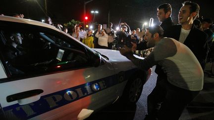 Des habitants de Boston f&eacute;licitent les policiers apr&egrave;s l'arrestation de Djokhar Tsarnaev, le second suspect de l'attentat de la ville, le 19 avril 2013.&nbsp;&nbsp; (BRIAN SNYDER / REUTERS)