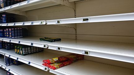 Des rayons vides dans un supermarché pendant la crise du Covid, le 14 mars 2020. (DAMIEN MEYER / AFP)