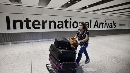 Une voyageuse arrivant à l'aéroport d'Heathrow, à Londres (Royaume-Uni), le 2 août 2021. (TOLGA AKMEN / AFP)