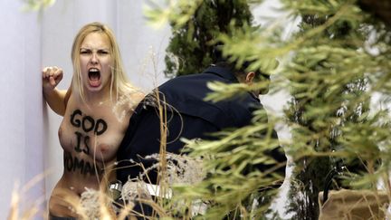 Une militante Femen arr&ecirc;t&eacute;e sur la place Saint-Pierre du Vatican, le 25 d&eacute;cembre 2014. (VINCENZO LIVIERI / AFP)