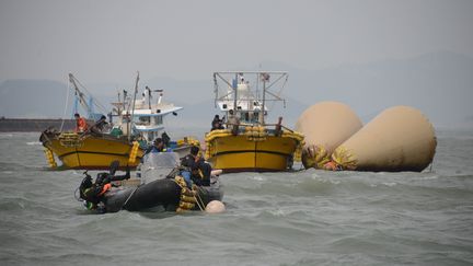 Les op&eacute;rations se poursuivent lundi 21 avril 2014 au large des c&ocirc;tes de Jindo (Cor&eacute;e du Sud), o&ugrave; les plongeurs tentent de retrouver des corps pi&eacute;g&eacute;s dans la coque du navire. (ED JONES / AFP)