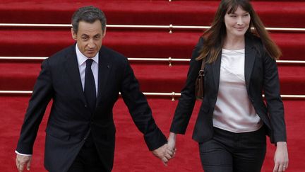 Pendant ce temps-l&agrave;, Nicolas Sarkozy et son &eacute;pouse Carla quittent main dans la main le palais de l'Elys&eacute;e. (PATRICK KOVARIK / AFP)