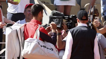 "Le Kosovo, c'est le cœur de la Serbie ! Stop à la violence." Après sa victoire facile du premier tour, le 29 mai 2023, Novak Djokovic prend position sur les tensions dans la région au moment de signer la caméra du tournoi. (JEAN CATUFFE / AFP)