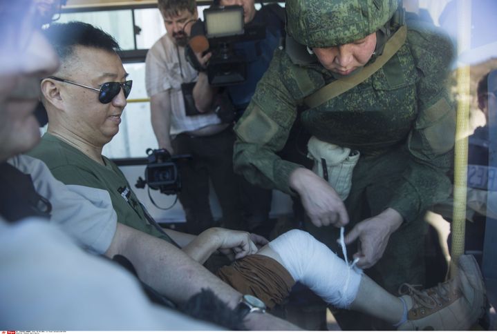 Un journaliste chinois reçoit des soins d'un soldat russe dans un blindé après les bombardements de leur convoi à Kinsibba, en&nbsp;Syrie, le&nbsp;1er mars 2016. (PAVEL GOLOVKIN / AP / SIPA)