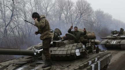 Des troupes prorusses autour d'un v&eacute;hicule militaire de l'arm&eacute;e ukrainienne, &agrave;&nbsp;Debaltseve, dans le district, de Donetsk, en Ukraine, le 14 f&eacute;vrier 2015. (VIKTOR KOSHKIN / ANADOLU AGENCY / AFP)