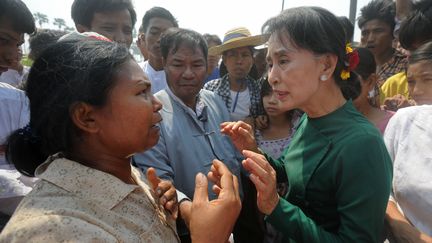 Aung San Suu Kyi discute avec une villageoise dans les environs de Monywa (Birmanie), le 14 mars 2013. (SOE THAN WIN / AFP)