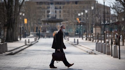 Un passant portant un masque dans les rues d'Aix-en-Provence, le 17 mars 2020. (CLEMENT MAHOUDEAU / AFP)