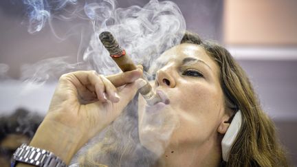 Une femme fume un cigare &agrave; La Havane (Cuba) lors du&nbsp;Festival du habano, le 27 f&eacute;vrier 2014. (ADALBERTO ROQUE / AFP)