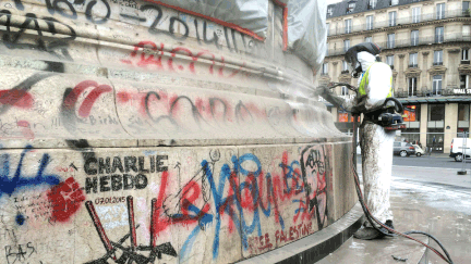 &nbsp; (Un agent de la mairie de Paris s'attaque aux tags sur la statue de la place de la République © radio France / Lauriane Delanoë)