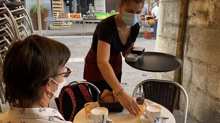 Une serveuse et une cliente après le déconfinement dans un bar d'Annecy (Haute-Savoie). Photo d'illustration. (RICHARD VIVION / FRANCE-BLEU PAYS DE SAVOIE)