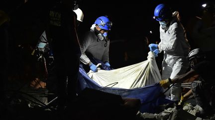 Les&nbsp;sauverteurs équatoriens transportent le corps d'une victimes, à Pedernales, le 20 avril 2016. (RODRIGO BUENDIA / AFP)