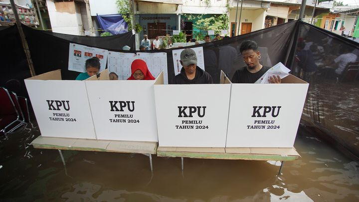 Des Indonésiens votent pour les élections générales, le 14 février 2024, dans un bureau de vote inondé, à Jakarta, la capitale du pays. (GEMMA GALGANI / XINHUA / MAXPPP)