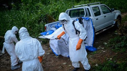 Des volontaires v&ecirc;tus de combinaisons sp&eacute;ciales apr&egrave;s la mort de plusieurs victimes du virus Ebola, &agrave; Kenema, en Sierra Leone, le 26 ao&ucirc;t 2014.&nbsp; ((MOHAMMED ELSHAMY / ANADOLU AGENCY / AFP))