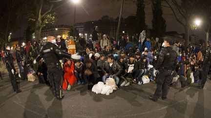 Des policiers encadrent les migrants du campement de Stalingrad, à Paris, lors de l'évaluation du campement vendredi 4 novembre 2016. (JOEL SAGET / AFP)