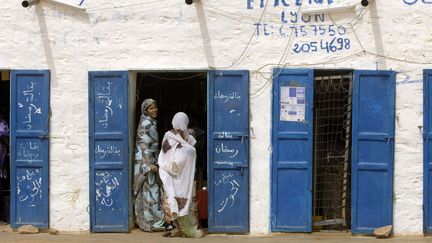 Des femmes discutent devant une épicerie de la nouvelle cité créée, par les Français en 1917, de l'autre côté de l'oued Chingetti pour la protéger de l'ensablement. Pendant la campagne électorale, des ministres ont sillonné le pays pour inciter les populations à s'inscrire massivement sur le nouveau fichier électoral. Le président Mohamed Ould Abdel Aziz, ancien général arrivé au pouvoir par un coup d'Etat en 2008, puis élu en 2009 et réélu en 2014, a appelé à un «vote massif» pour son parti, l'Union pour la République (UPR). L'opposant Ahmed Ould Daddah, chef du Rassemblement pour la démocratie (RFD), la appelé les électeurs au «sursaut nécessaire pour balayer le régime de la dictature et de la faillite généralisée». Il dénonce une forte baisse du pouvoir d'achat depuis l'introduction le 1er janvier de nouveaux billets de l'ouguiya, monnaie nationale dont la valeur a été divisée par dix. L'opposition  dénonce aussi un «endettement excessif» de près de 100% du PIB et des indices de développement plaçant le pays «au bas de l'échelle à tous les niveaux».

	  (PHILIPPE ROY / AURIMAGES )