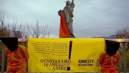 Des militants d'Amnesty International protestent à Paris, le 10 janvier 2012, contre le centre de détention américain, 10 ans après l'arrivée des premiers prisonniers sur la base située à Cuba. (AFP PHOTO JOEL SAGET)