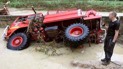 Un homme constate loes d&eacute;g&acirc;ts son tracteur renvers&eacute; par les eaux, le 6 novembre 2011 &agrave; Auribeau-sur-Siagne dans les Alpes maritimes. (VALERY HACHE / AFP)