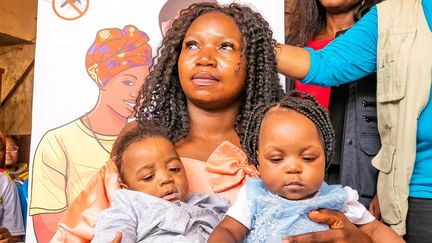 Une femme avec ses deux enfants lors de la campagne de vaccination au Cameroun, le 22 janvier 2024. (ETIENNE NSOM / AFP)