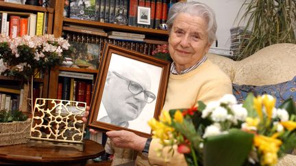  Raymonde Tillon porte le portrait de son mari, le 26 avril 2005, à Nantes (Loire-Atlantique).&nbsp; (FRANK PERRY / AFP)