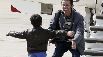 Le journaliste espagnol Javier Espinosa est accueilli par son fils sur la base militaire de&nbsp;Torrejon de Ardoz (Espagne) apr&egrave;s avoir pass&eacute; plus de six mois en d&eacute;tention en Syrie, le 30 mars 2014. (PACO CAMPOS / AFP)