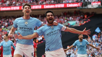 Les joueurs de Manchester City John Stones (à gauche) et Ilkay Gündogan lors de la finale de FA Cup contre Manchester United, à Londres, le 3 juin 2023. (ADRIAN DENNIS / AFP)