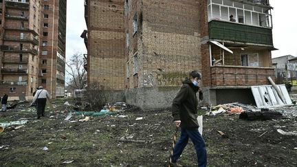 Des civils marchent à côté d'un bâtiment résidentiel endommagé après une frappe de missile russe dans la ville de Kostyantynivka, dans la région de Donetsk, à l'est de l'Ukraine, le 2 avril 2023. (GENYA SAVILOV / AFP)