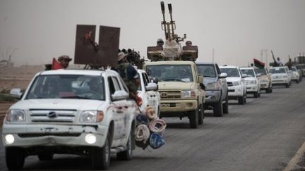 Les rebelles libyens sur la route entre Ajdabiya et Brega, ville pétrolière située sur la ligne de front (14/07/2011). (GIANLUIGI GUERCIA / AFP)