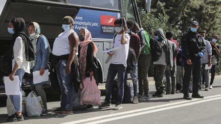 Des migrants attendent leur transfert vers la Grèce continentale, depuis l'île de Lesbos, le 28 septembre 2020. (MANOLIS LAGOUTARIS / AFP)