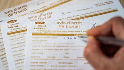 Un médecin remplit un formulaire d'arrêt de travail le 22 février 2024. (JEAN-MARC BARRERE / HANS LUCAS / AFP)