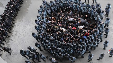 Des policiers anti-&eacute;meutes s'entra&icirc;nent &agrave; canaliser des hooligans au stade de Lviv (Ukraine), le 19 avril 2012. (YURIY DYACHYSHYN / AFP)