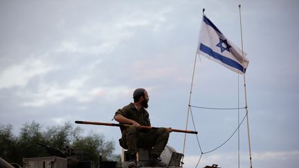 Un soldat israélien est assis sur un char stationné près de la frontière nord d'Israël avec le Liban, le 30 octobre 2023. (JALAA MAREY / AFP)