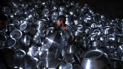 Un enfant au travail dans une entreprise de produits en aluminium au Bangladesh en 2015. (MAXPPP)