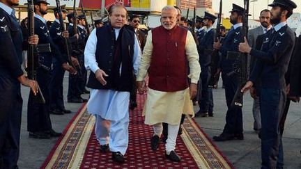 Le Premier ministre indien, Narendra Modi, et son homologue pakistanais, Nawaz Sharif, se tenant par la main à l'aéroport de Lahore le 25 décembre 2015. (AFP - INDIAN PRESS INFORMATION OFFICE - ANADOLU AGENCY)