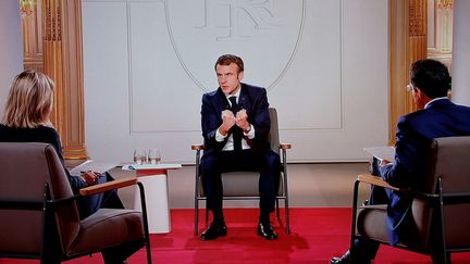 Le président de la République, Emmanuel Macron, répond depuis l'Elysée aux questions d'Audrey Crespo-Mara et de Darius Rochebin, sur TF1, mercredi 15 décembre 2021. (LUDOVIC MARIN / AFP)