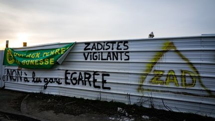 Des tags contre un projet de gare sur une palissade à l'entrée du Triangue de Gonesse, dans le Val-d'Oise, le 13 février 2021. (GEOFFROY VAN DER HASSELT / AFP)