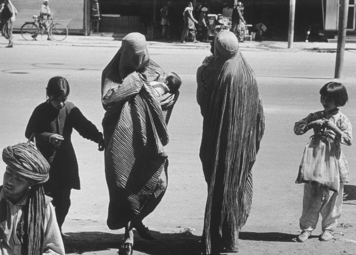 Two Afghan women accompanied by children cross a street in Kabul (Afghanistan) in 1972. (LAURENCE BRUN / GAMMA-RAPHO / GETTY IMAGES)