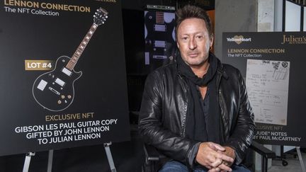 Julian Lennon&nbsp;devant l'affiche de la "Lennon Connection : The NFT Collection" qu'il a organisée le 7 février 2022. (VALERIE MACON / AFP)