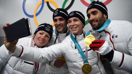 Les biathlètes français&nbsp;Marie Dorin Habert, Simon Desthieux, Anais Bescond et Martin Fourcade posent avec leurs médailles olympiques, le 21 février 2018, à Pyeongchang (Corée du Sud). (FRANCK FIFE / AFP)