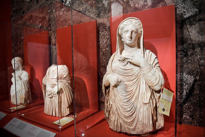 Trois des quatre statues funéraires de Cyrène, en Libye orientale, exposées temporairement au Louvre, à Paris (21 mai 2021) (ALAIN JOCARD / AFP)