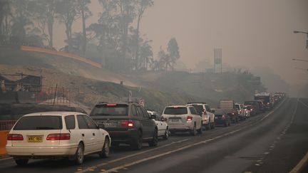 Des voitures quittent la ville de Batemans Bay en Nouvelle-Galles du Sud (Australie) pour se diriger vers le nord afin de fuir les incendies, le 2 janvier 2020. (PETER PARKS / AFP)