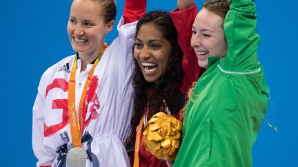 Le sourire éblouissant et le bras levé des trois nageuses gagnantes du 100 m brasse des Jeux Paralympiques de Rio : à gauche, la médaille d'argent Britannique&nbsp;Bethany Firth,&nbsp;au centre, la médaille d'or espagnole&nbsp;Michelle Alonso Morales, à droite, la médaille de bronze nééerlandaise Magda Toeters. (AL TIELEMANS FOR OIS / AFP)