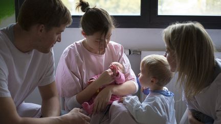 En salle des familles, un nourrisson rencontre pour la première fois son oncle et sa tante, le 27 mars 2016, dans une maternité de Chambéry (Savoie). (ULYSSE LEFEBVRE / HANS LUCAS / AFP)