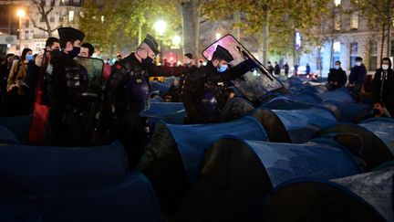 Des gendarmes tentent d'évacuer des tentes de migrants place de la République, à Paris, 23 novembre 2020. (MARTIN BUREAU / AFP)