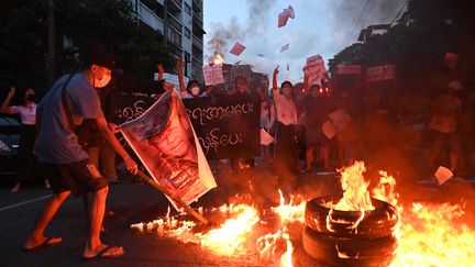 Des manifestants brûlent une photo du chef de la junte militaire birmane,&nbsp;Min Aung Hlaing, lors d'une manifestation à&nbsp;Rangoun, le 10 novembre 2021. (AFP)