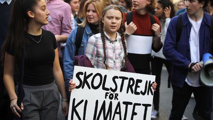 Greta Thunberg, au centre, lors d'une marche pour le climat organisée à Paris le 22 février 2019.&nbsp;L'adolescente suédoise a été à l'initiative d'un&nbsp;mouvement international de collégiens et de lycéens qui boycottent leur établissement le vendredi pour participer à des manifestations contre le réchauffement climatique. (FRANCOIS MORI / AP / SIPA)