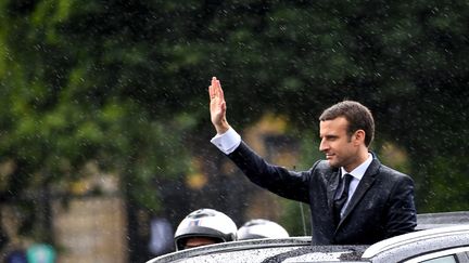 Emmanuel Macron brave la pluie sur les Champs-Elysées, rappelant l'image d'un François Hollande détrempé, lui aussi, le jour de son investiture. (ERIC FEFERBERG / AFP)