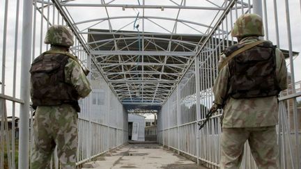 Des gardes-frontières ouzbeks veillent sur un pont surplombant le fleuve Kara-Su entre le Kirghizistan et l'Ouzbékistan. En face, le poste-frontière kirghize, abandonné. (REUTERS/SHAMIL ZHUMATOV)